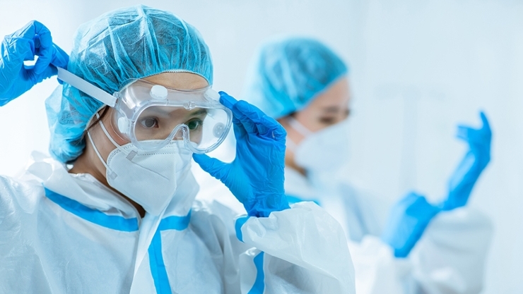 © iStock | RyanKing Employees in protective clothing in the laboratory