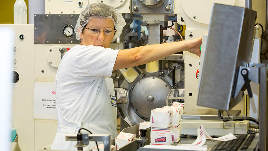 Frau an einer Maschine in einer Margarinefabrik
